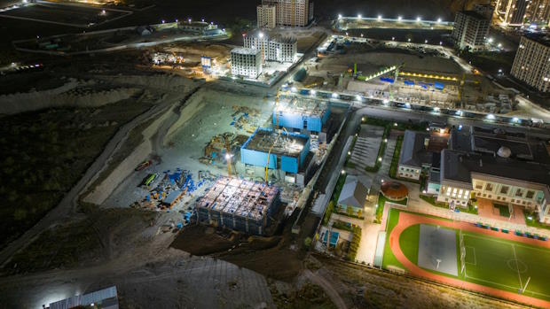 Bouwplaats van bovenaf in de nacht