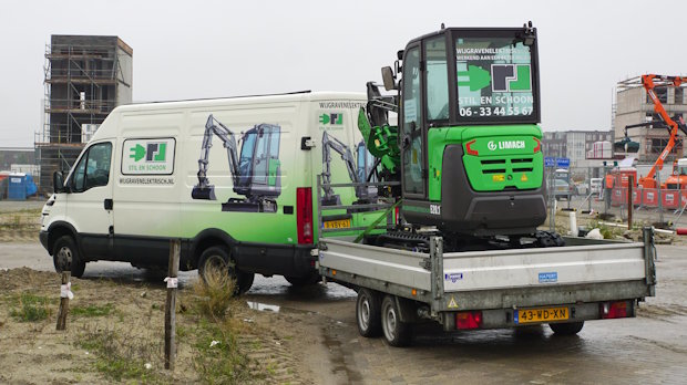 Bestelwagen die een aanhanger met daarop een minigraver