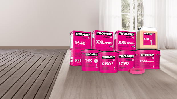 Producten van THOMSIT voor het installeren en afwerken van vloerverwarmingssystemen, gepresenteerd op een vloer met vloerverwarming.