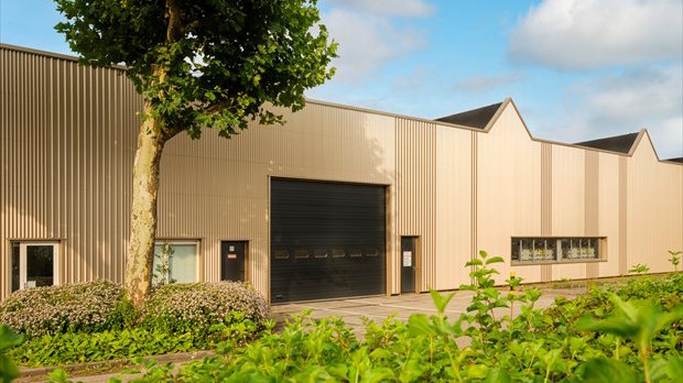 Gevelrenovatie productiehal met nieuwe geïsoleerde gevel en moderne uitstraling op industrieterrein.