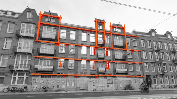 Grayscale photo of a brick apartment building with bright orange scaffolding outlining the facade.